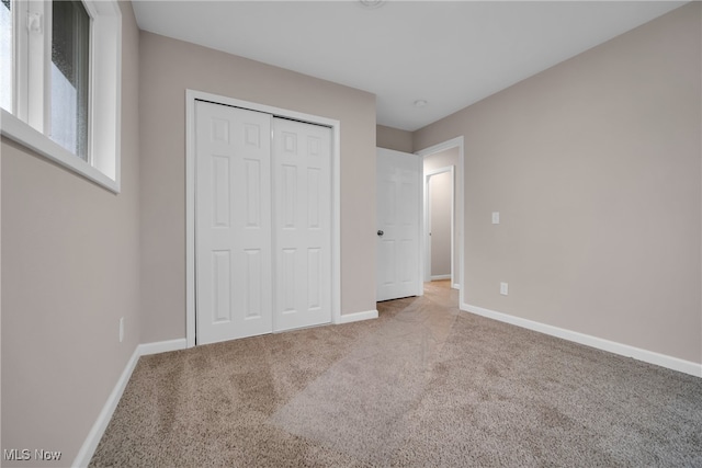 unfurnished bedroom featuring carpet and a closet