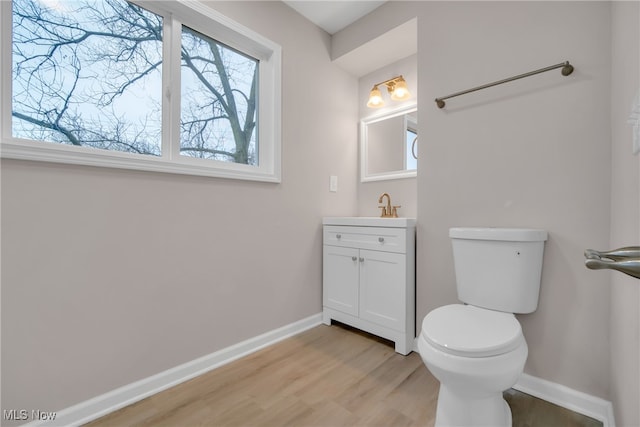 bathroom with vanity, wood-type flooring, and toilet