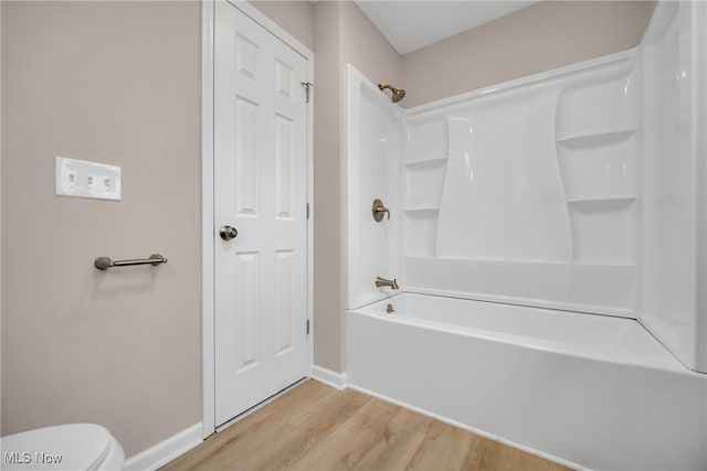 bathroom featuring toilet, wood-type flooring, and shower / tub combination