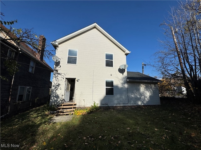 rear view of property featuring a lawn