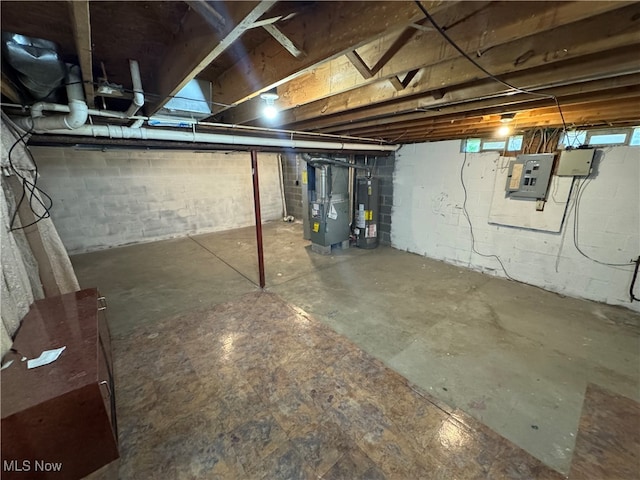 basement with heating unit, electric panel, and gas water heater