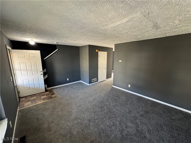 carpeted spare room with a textured ceiling