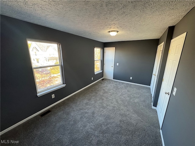 unfurnished bedroom featuring carpet flooring and a textured ceiling