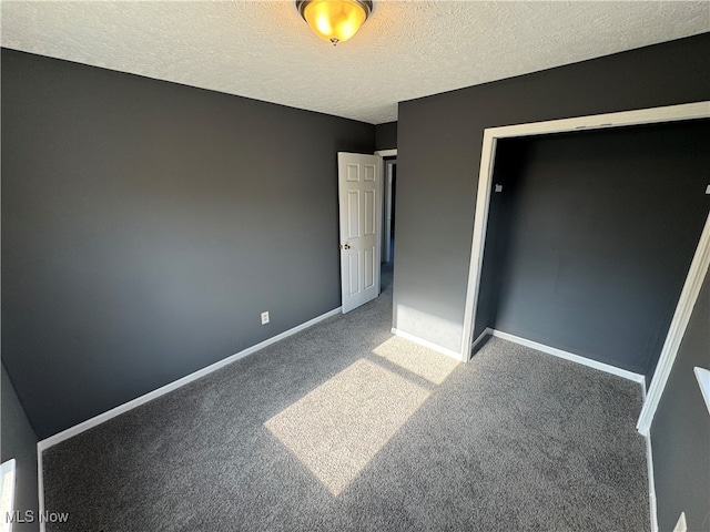 unfurnished bedroom featuring a closet, carpet, and a textured ceiling