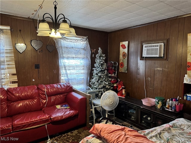 living room with an inviting chandelier, a wall mounted AC, and wooden walls