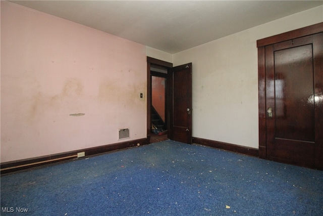 unfurnished room featuring dark colored carpet