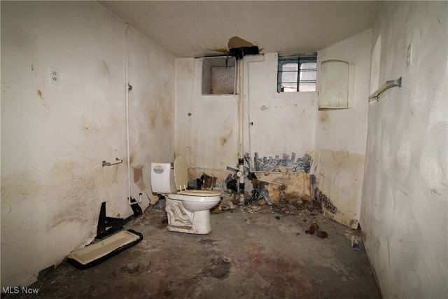 bathroom featuring concrete floors and toilet