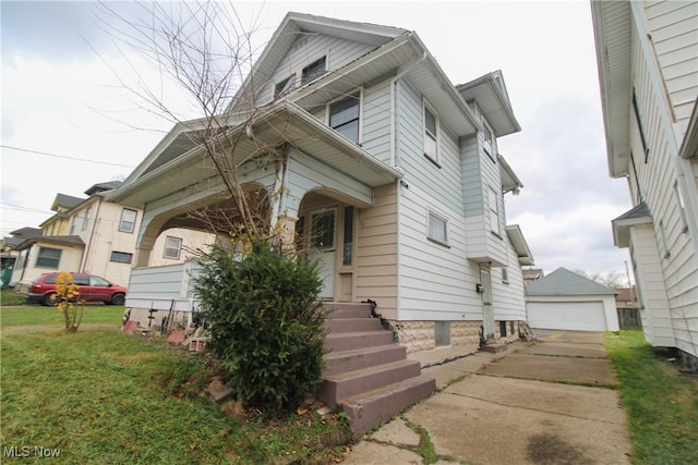 view of front of property featuring a front lawn, an outdoor structure, and a garage