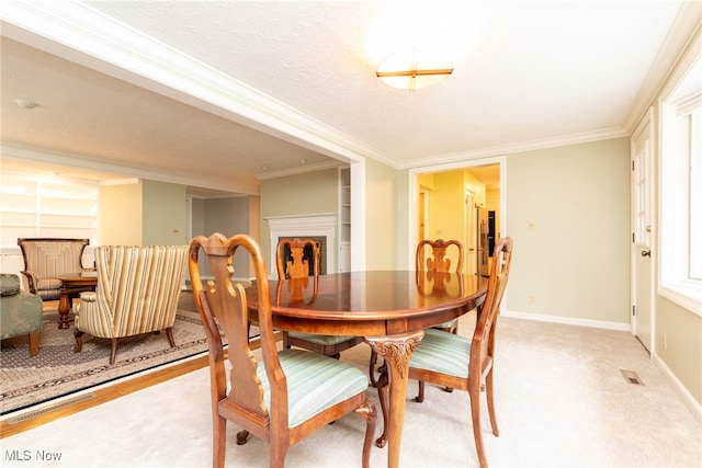 dining space with ornamental molding, a textured ceiling, and light hardwood / wood-style flooring