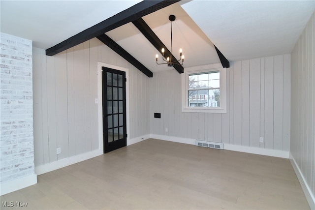 spare room featuring lofted ceiling with beams, wooden walls, and a notable chandelier