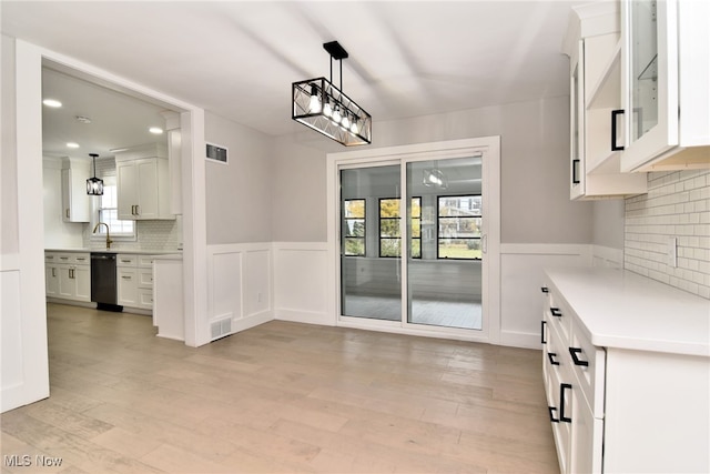 unfurnished dining area with sink and light wood-type flooring