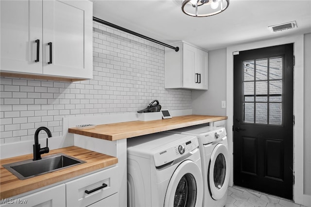 laundry area with cabinets, independent washer and dryer, light tile patterned flooring, and sink