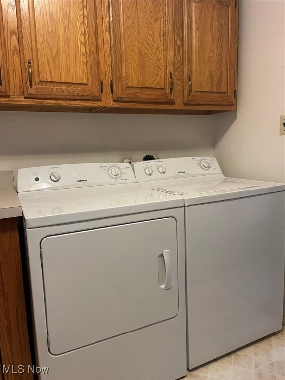 laundry room featuring cabinets and washing machine and clothes dryer