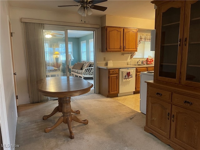 kitchen featuring light carpet, stainless steel dishwasher, white range oven, ceiling fan, and sink