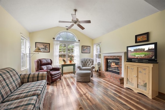 living room featuring hardwood / wood-style flooring, ceiling fan, lofted ceiling, and a fireplace