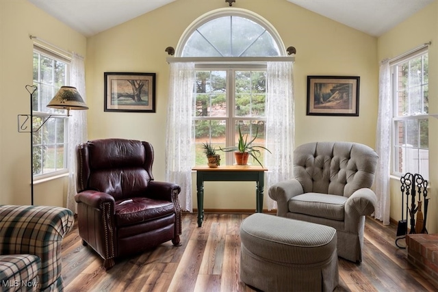 living area with vaulted ceiling and hardwood / wood-style flooring