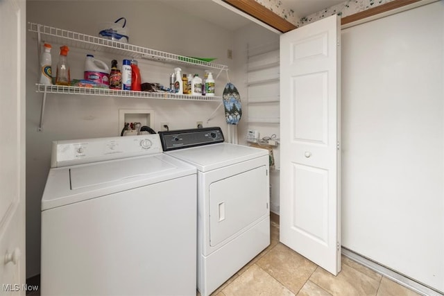 clothes washing area featuring light tile patterned floors and washing machine and clothes dryer