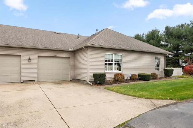 view of side of property with a lawn and a garage