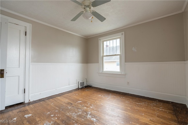 spare room featuring a textured ceiling, ceiling fan, dark hardwood / wood-style floors, and ornamental molding