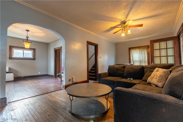 living room featuring hardwood / wood-style floors, a textured ceiling, ceiling fan, and crown molding