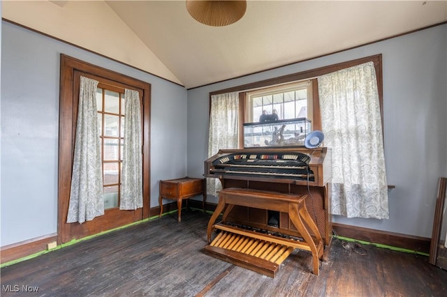living area with vaulted ceiling, wood finished floors, and baseboards