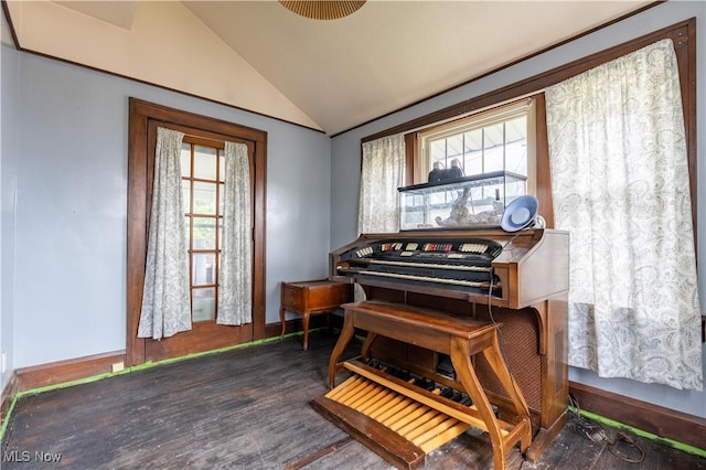 living area featuring vaulted ceiling, wood finished floors, and baseboards