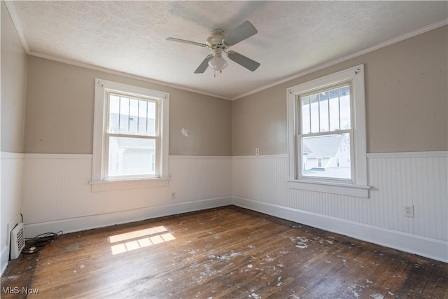 spare room featuring hardwood / wood-style floors, plenty of natural light, and wainscoting