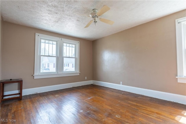 empty room with baseboards, a textured ceiling, ceiling fan, and wood-type flooring