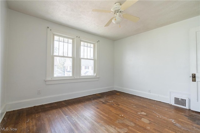 spare room with a textured ceiling, baseboards, visible vents, ceiling fan, and wood-type flooring