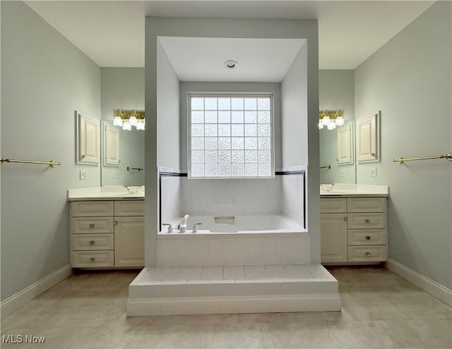 bathroom with tile patterned floors, vanity, and a relaxing tiled tub