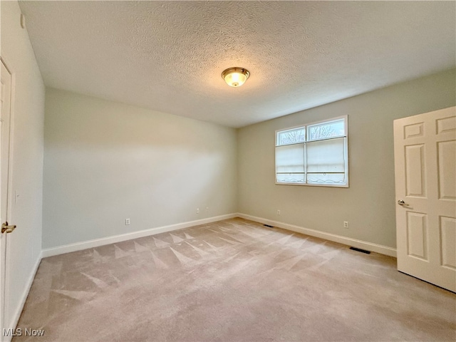 unfurnished bedroom featuring light carpet and a textured ceiling