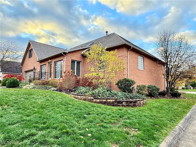 view of side of property featuring a lawn and a garage