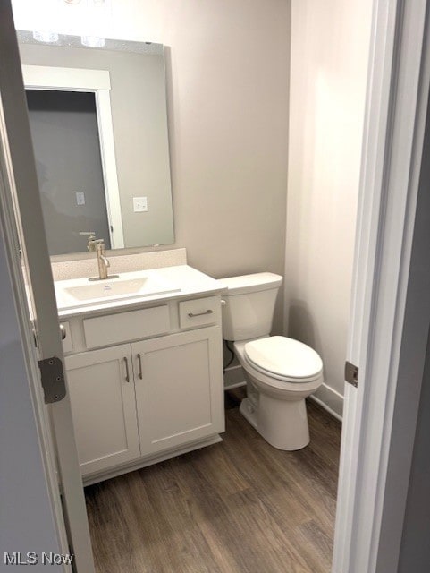 bathroom with vanity, hardwood / wood-style floors, and toilet