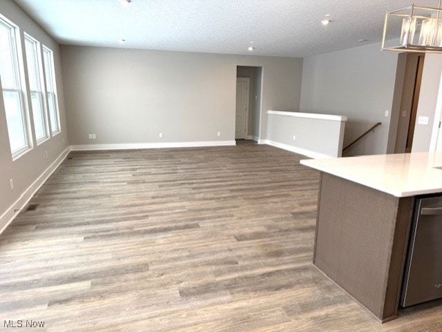 unfurnished room with a textured ceiling and light hardwood / wood-style flooring