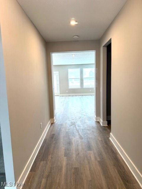 corridor with dark hardwood / wood-style flooring