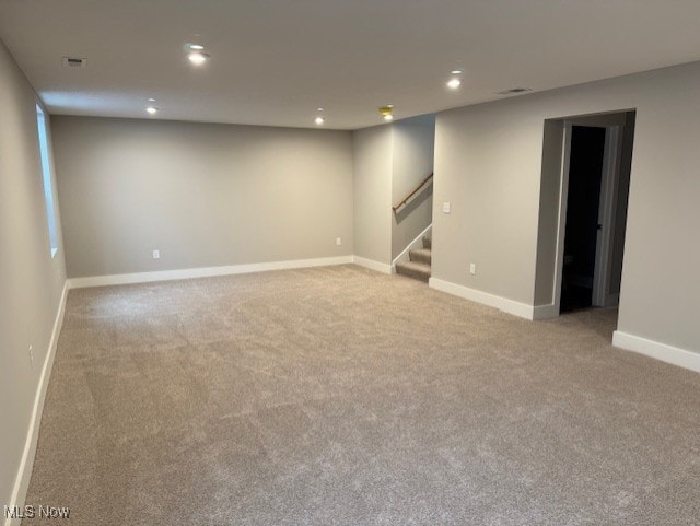 basement featuring light carpet