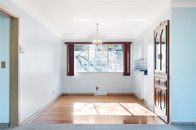 unfurnished dining area featuring light wood-type flooring and a chandelier