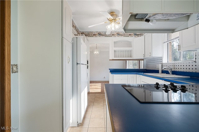 kitchen with white cabinetry, sink, white fridge, and exhaust hood