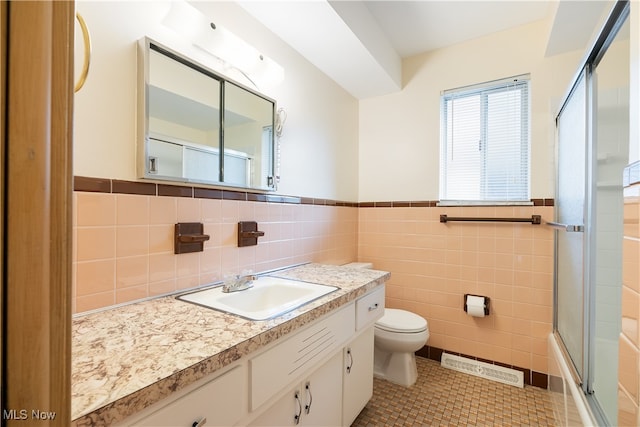 full bathroom featuring tile patterned floors, vanity, tile walls, enclosed tub / shower combo, and toilet