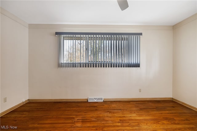 empty room with ceiling fan, hardwood / wood-style floors, and crown molding