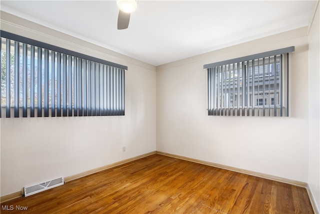 empty room with ceiling fan, crown molding, and hardwood / wood-style flooring