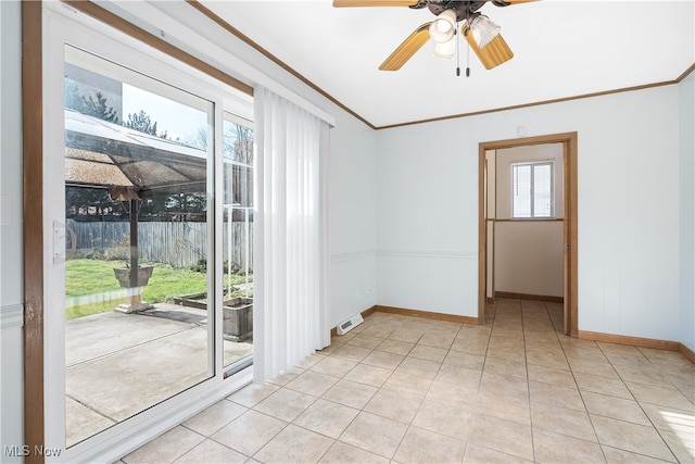 spare room featuring light tile patterned floors, crown molding, ceiling fan, and a healthy amount of sunlight