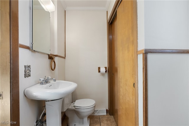 bathroom featuring tile patterned flooring, toilet, and crown molding