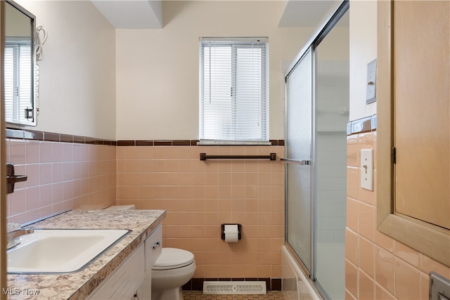 full bathroom featuring vanity, toilet, tile walls, and a wealth of natural light