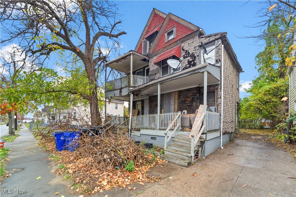 view of front facade featuring covered porch and a balcony