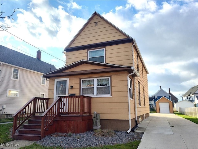 975 Broad St, Conneaut, OH 44030 - american foursquare style home with concrete driveway, a detached garage, and an outbuilding