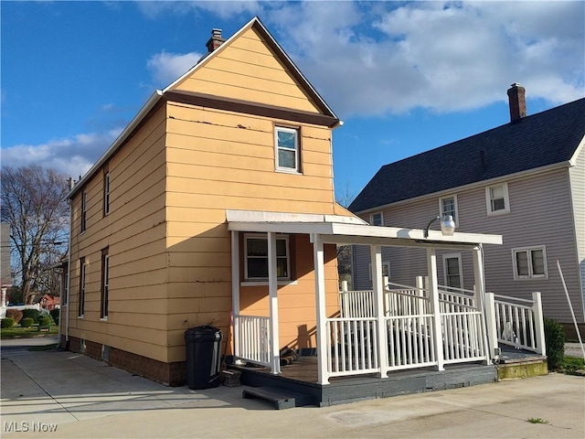 975 Broad St, Conneaut, OH 44030 - rear view of property with a porch and a chimney