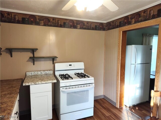 975 Broad St, Conneaut, OH 44030 - kitchen featuring white appliances, dark wood-style floors, ceiling fan, light stone counters, and white cabinets
