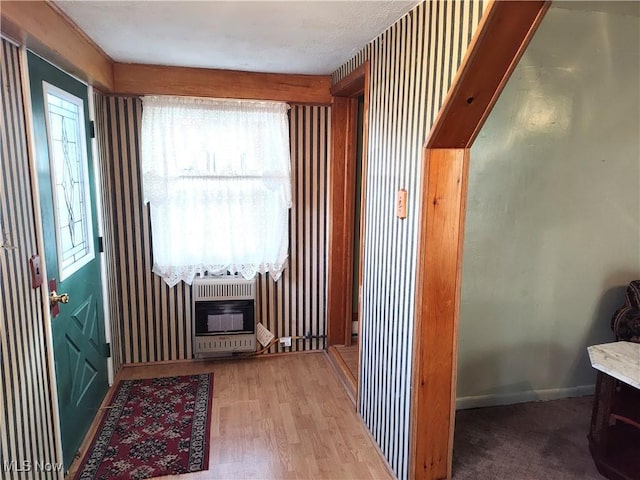975 Broad St, Conneaut, OH 44030 - hall featuring heating unit, plenty of natural light, and wood finished floors
