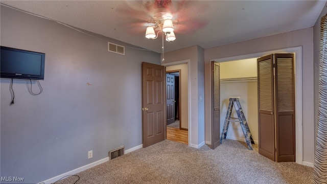 unfurnished bedroom with ceiling fan, a closet, and light colored carpet